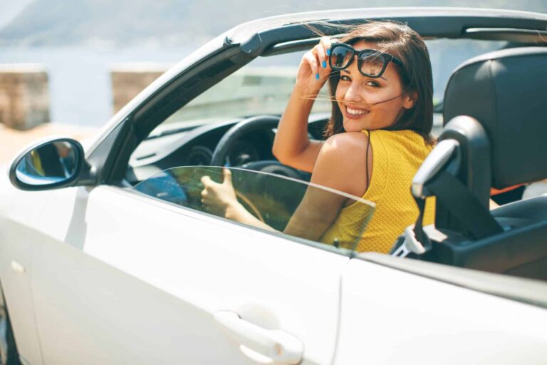 A pretty, attractive young woman in a white convertible car makes more money than her friends, which is why she drives an expensive car.
