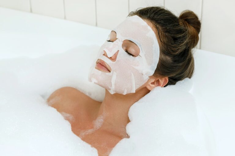 A woman relaxes in a bubble bath while wearing a collagen mask, enjoying a soothing skincare moment.